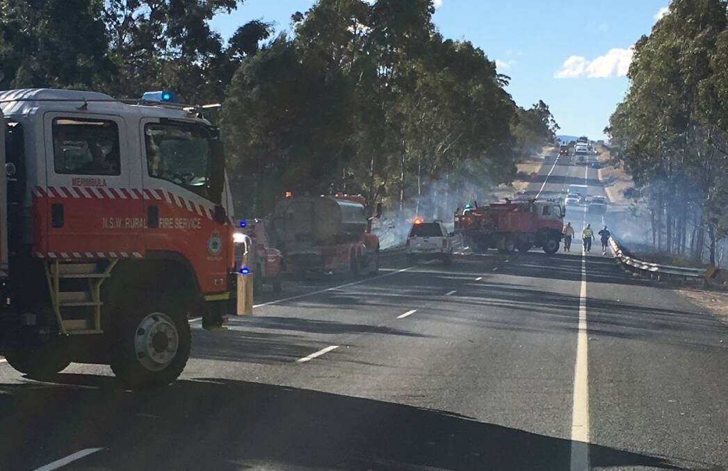 SMOKY: Rural Fire Service personnel on the scene at a grass fire that briefly closed the Princes Highway at Frogs Hollow on May 23. Picture: Paul Sharp