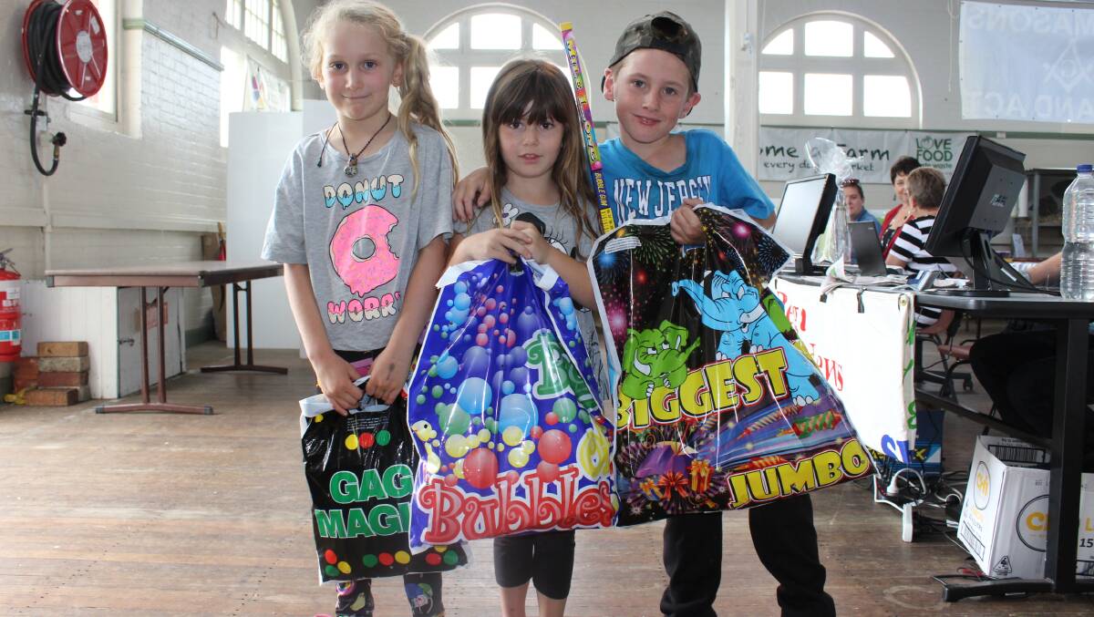 Jayla Gilbert from Eden, Paige Hosford from Heyfield in Victoria and Brett Hosford from Eden with new show bags in hand at the 2016 Bega Show.