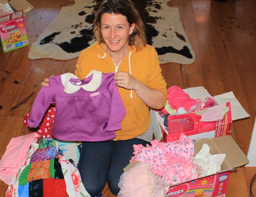 Narelle Hutchinson with just a few of the clothes she is about to put on display for the kids' clothes swap. 