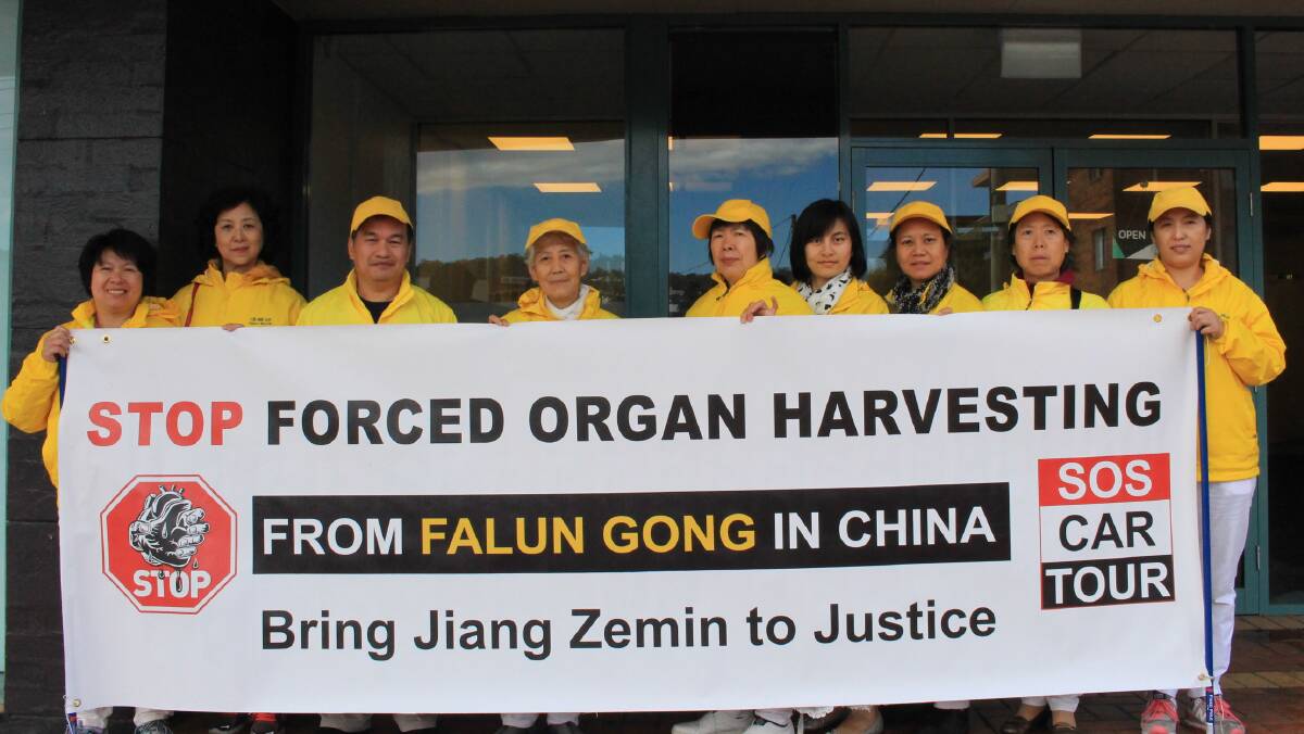 Falun Gong supporters and victims of Chinese oppression outside the Fairfax office of the Merimbula News Weekly on Tuesday morning.