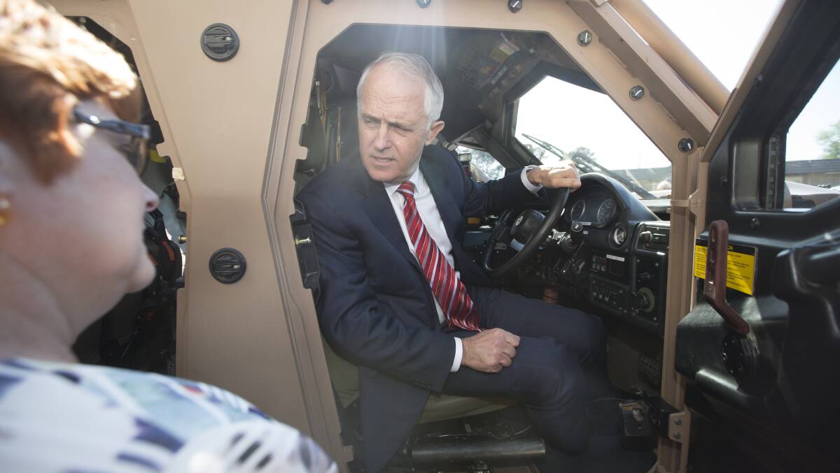 IMPRESSED: Prime Minister Malcolm Turnbull gets behind the wheel of a Hawkei light-armoured vehicle as Defence Minister Marise Payne looks on. Thales Australia has won the right to manufacture 1100 of the vehicles from its Bendigo plant.