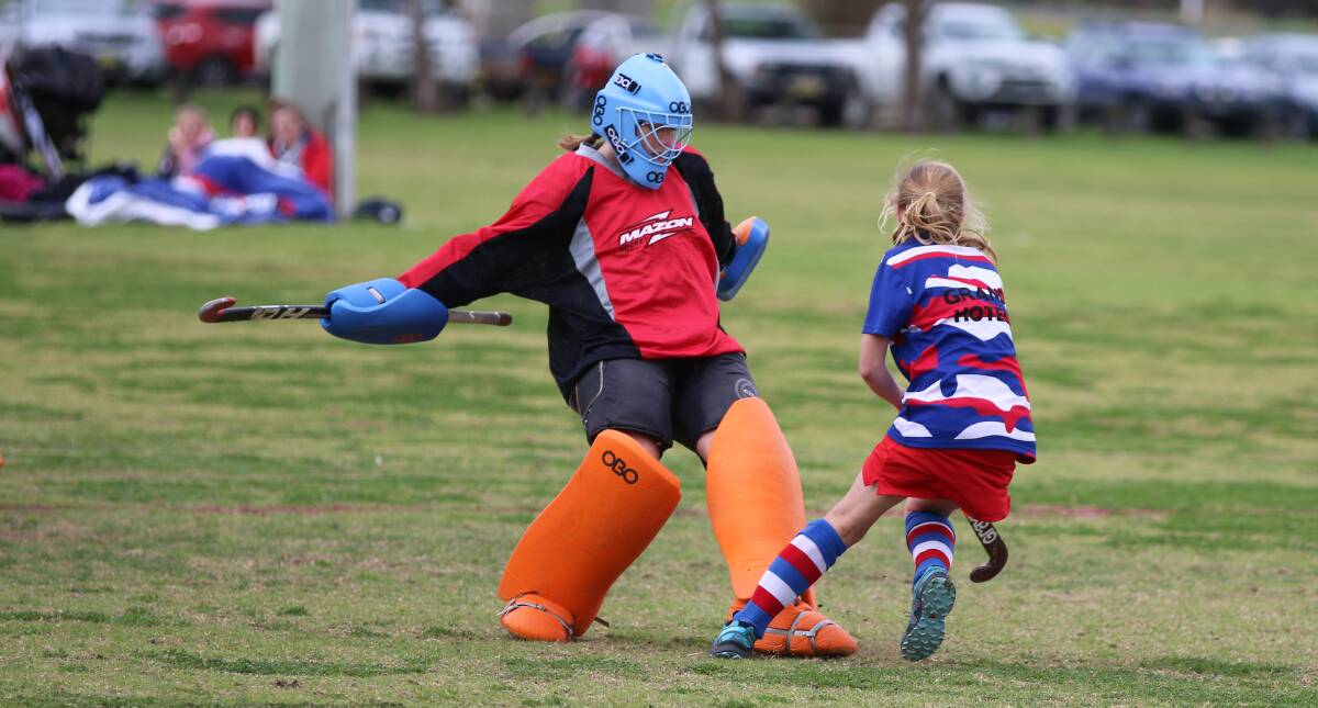 Shot denied: A junior goalie defends a shot by a member of the Grand B grade squad in a recent hockey match. 