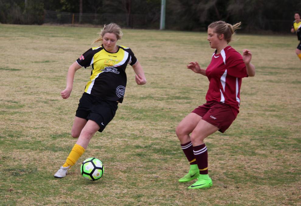 Tegan Grant takes control of the ball over her Tathra opponent during the minor semi-final in Merimbula on Sunday. 