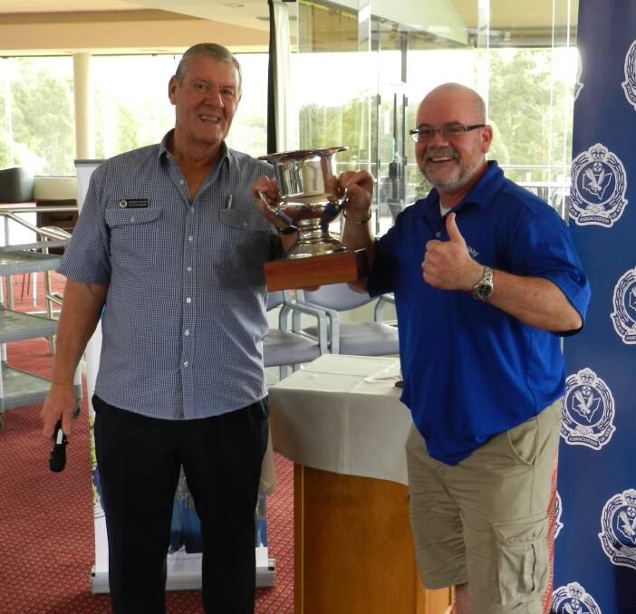 Friendly rivalry: Peter Weir presents the winners' trophy to NSW Ambulance’s David Oliver at the last Emergency Services Golf Day. 