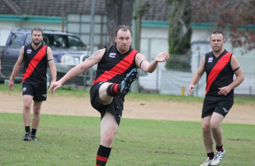• Bomber Wayne Flinn (centre) kicks a pass with support from Justin Welsford and John Harney during a recent match. 