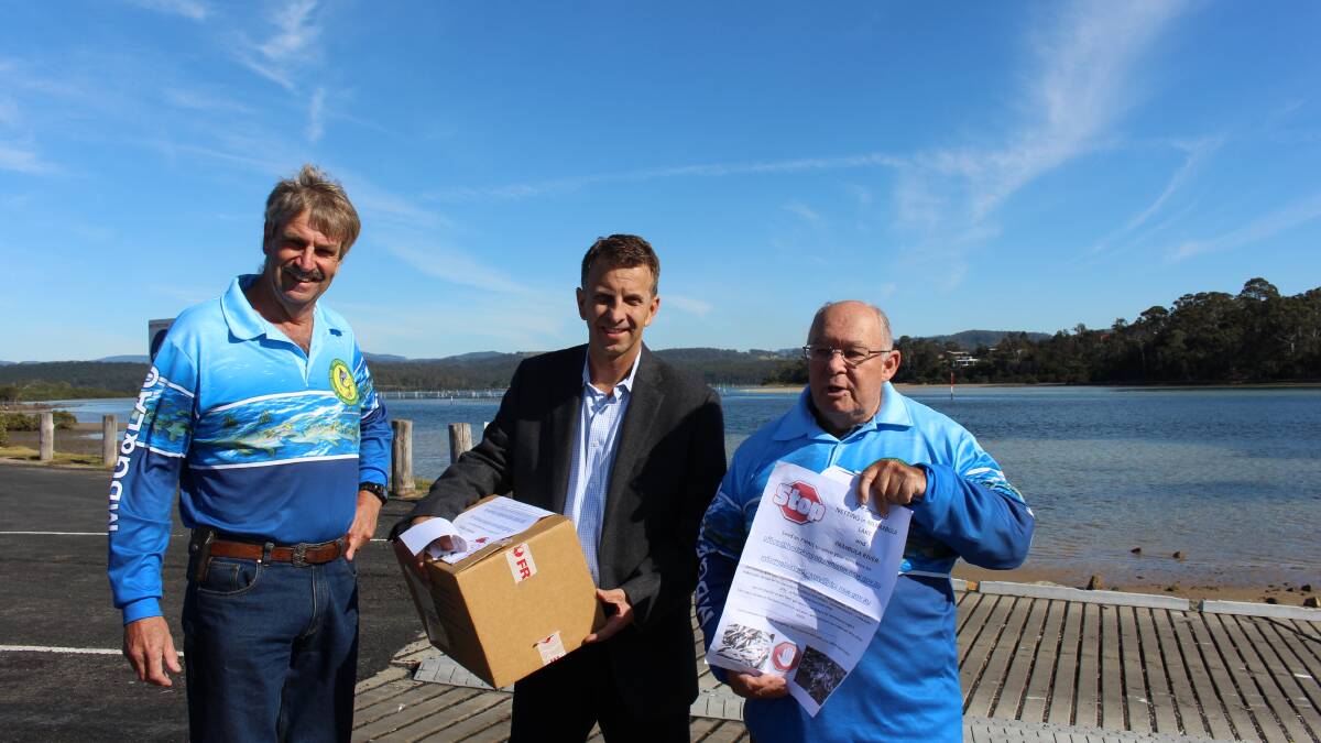 Member for Bega, Andrew Constance, centre, receives petitions against netting in Merimbula's Top Lake from Merimbula Big Game and Lakes Angling Club members, David Dulhunty, left and Chris Young. 