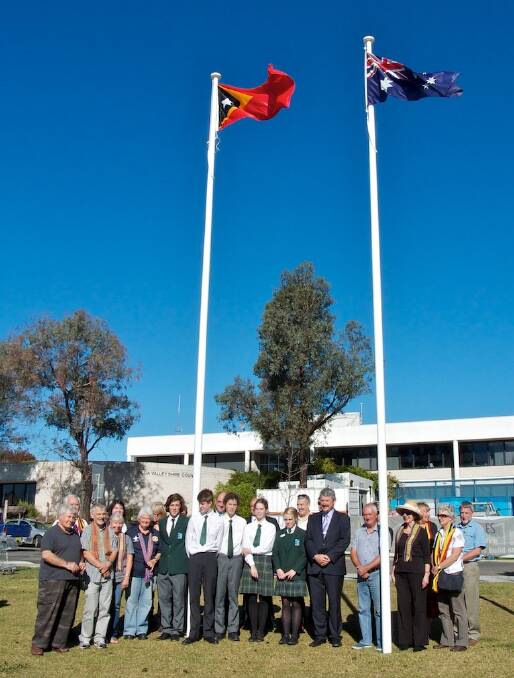 Members of the Bega Valley Advocates for Timor Leste along with councillors and students from the Bega Valley Anglican College raise the flag in Littleton Gardens to mark Timor Leste Independence Day. 