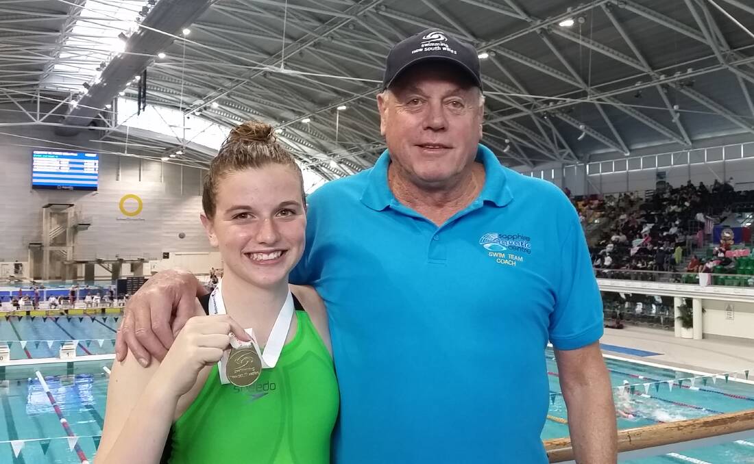 Gold: Eden's Georgia Caldwell and coach John Pelling with a gold medal for 100m freestyle at the NSW Short Course Country Championships in Sydney last weekend.