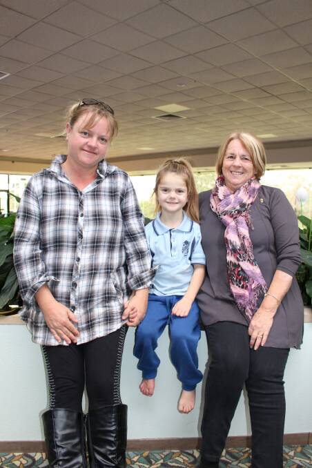 Seven-year-old Emma Peck with her mum Kerrie Peck, left, and Pambula Merimbula Lions Club representative and family friend, Maureen Stokes. 