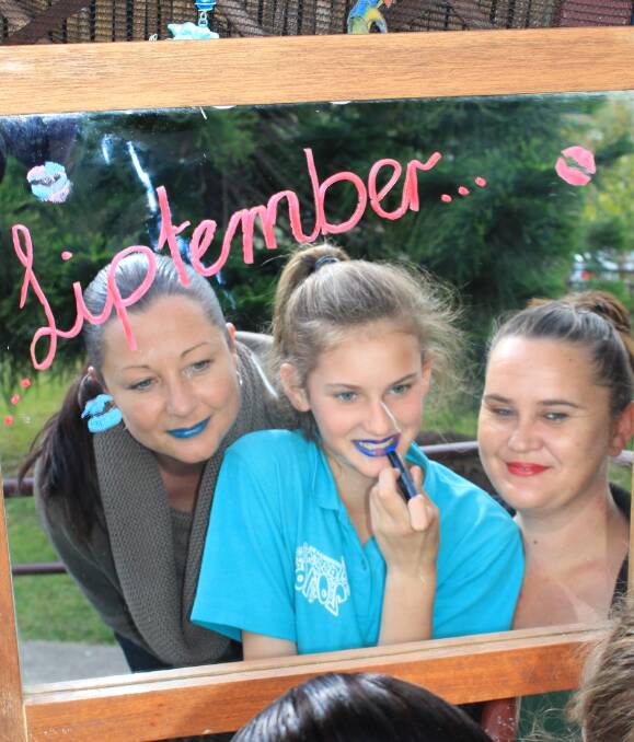 Colourful kisses: Jodie Taylor, 11-year-old Christine Sims and Cindy Rea show off their bright liptember lips to raise money and awareness for women's mental health. Picture: Melanie Leach