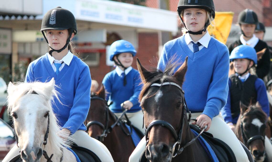 PARADING IN TOWN: Members of the Pambula Pony Club ride down the main street of Bega on Tuesday as part of the Bega Pony Club Camp. Picture: Albert McKnight