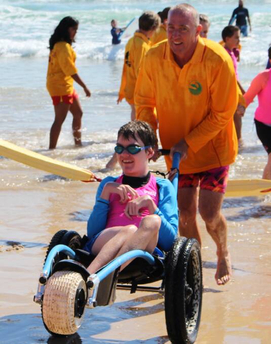 Jake at Pambula Beach in a beach wheelchair.