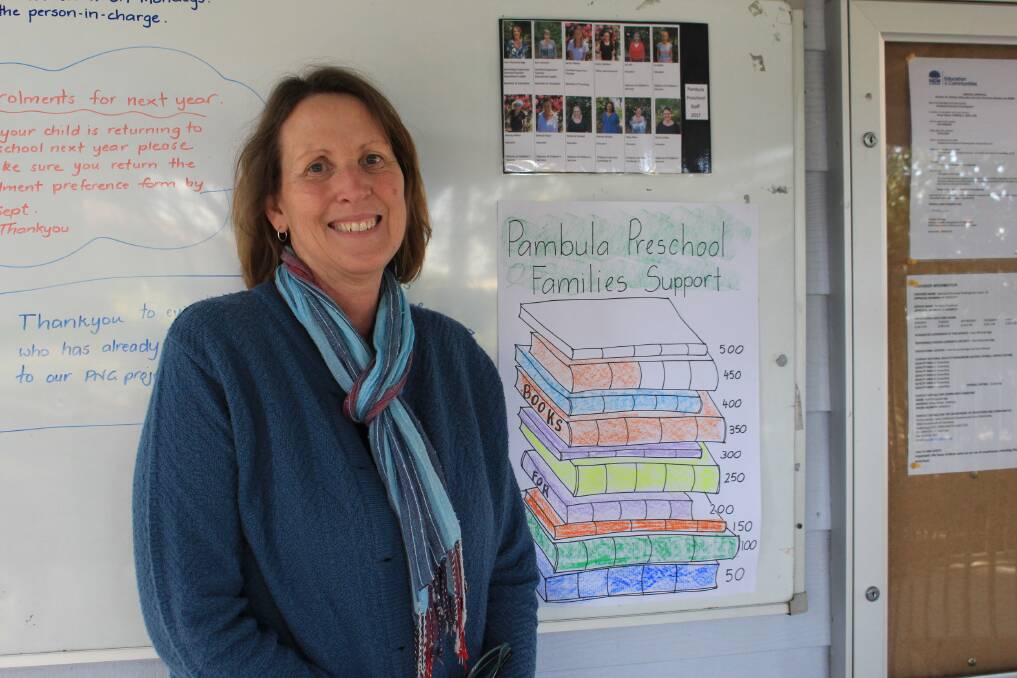Pambula Preschool director Pam McCambridge stands with the chart showing how many books were ready to be donated. 