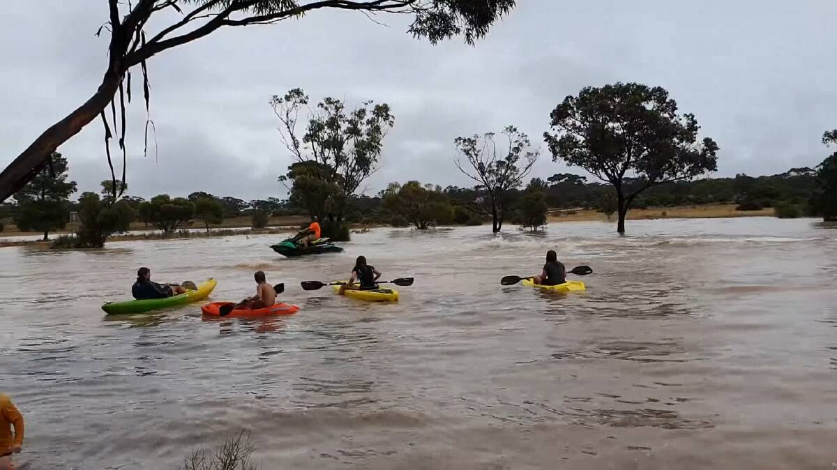 Four children paddled in kayaks while a jet ski created waves and splashed them at the flooded Wirrulla Golf Course on SA's Eyre Peninsula on Friday, January 21. Photo: Lisa Olsson