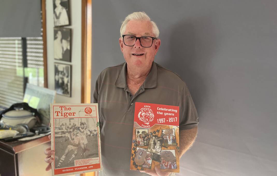 Don 'Flaps' Wilson at his home in Eden holding a vintage Eden Tiger's yearbook and another on the history of the Tigers from 1997 to 2017. Picture by James Parker