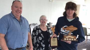 Jack Pollock, 15-year-old member from Greigs Flat, is awarded the annual 2021-22 NSW GFA Southern Zone Yellowfin Tuna trophy by president Steve Lamond and secretary Sanchia Glaskin.