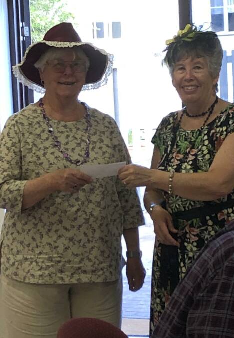 Dawn Williams presents Imlay Nursing Home Auxiliary president Beverley Brown $300 raised at Acacia Ponds' social club high tea and mad hatters tea party. 