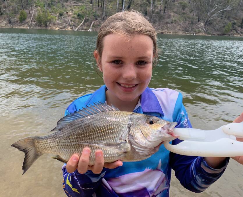 Junior angler Emily OBrien, 8, of Wellington NSW, shows a lovely catch and release bream at Thompsons, Bega River.