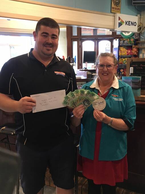 Sean Stolzenhein, Royal Willows Hotel manager, presents Shirley Rixon with $1000 for the Pambula Hospital Auxiliary.