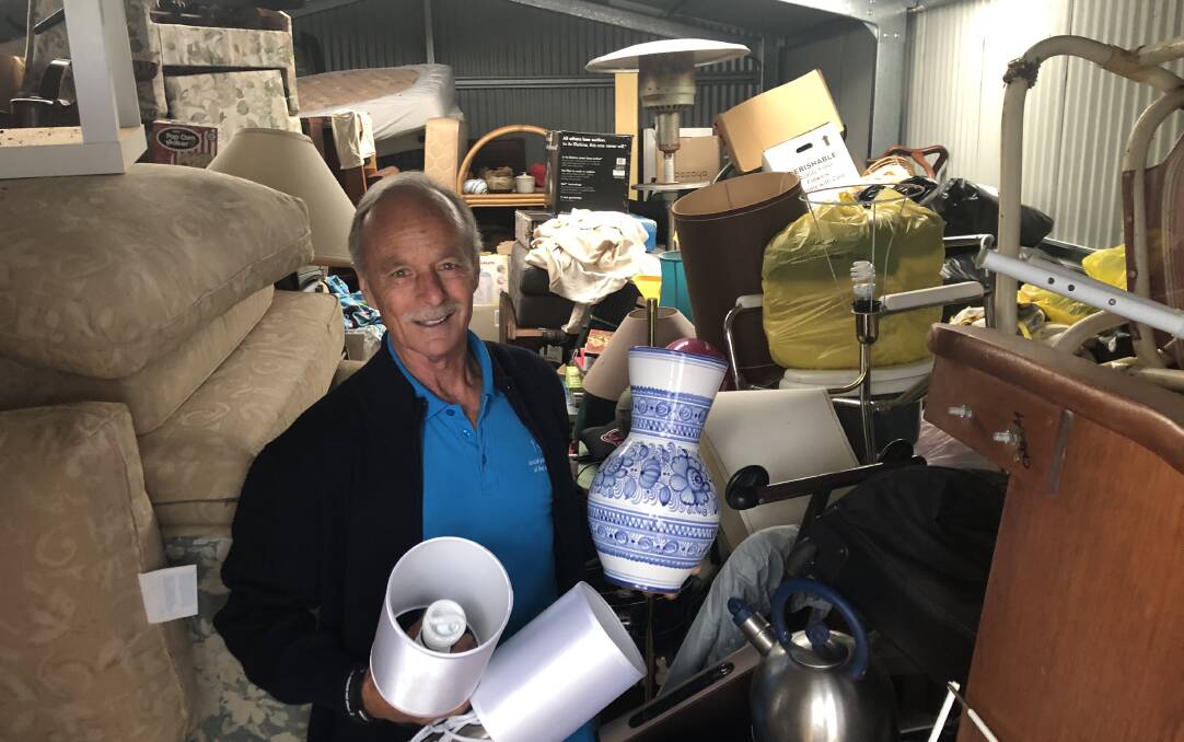 Social Justice Advocates of the Sapphire Coast member Mick Brosnan checks out the donated items in storage ahead of this month's Samaritan op shop.