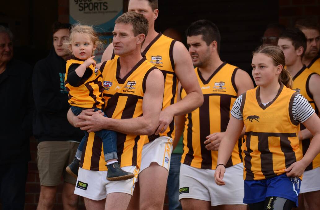 Pambula Panthers player Sean Smith walks out with pride alongside two of his daughters and the senior men's team for his 200th game for the club on Saturday. 
