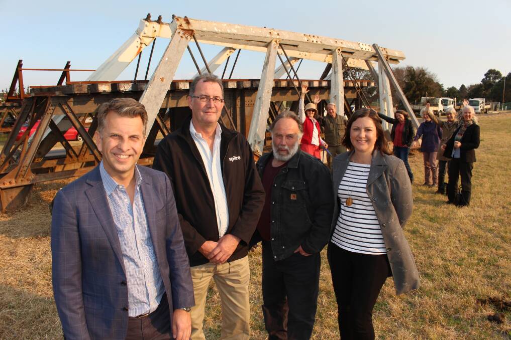Member for Bega Andrew Constance, project manager Phil Baird, Wyndham Progress Association president Bob Hunt and Mayor Kristy McBain stand before the heritage listed trusses stored at a council depot in Bega. 