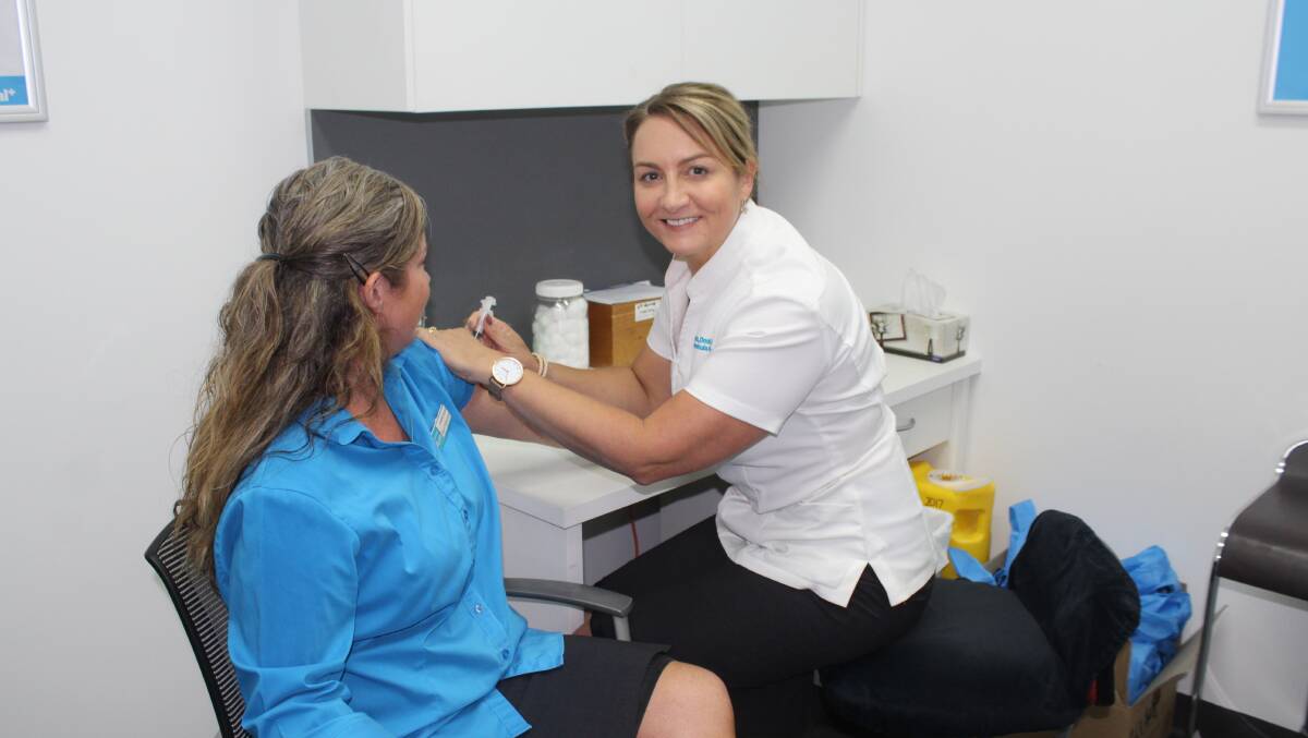 THE TIME IS NOW: Tania Dwyer from Seeto, Dodd and Dwyer Merimbula Pharmacy delivers the flu vaccine to employee Kylie Grey. 