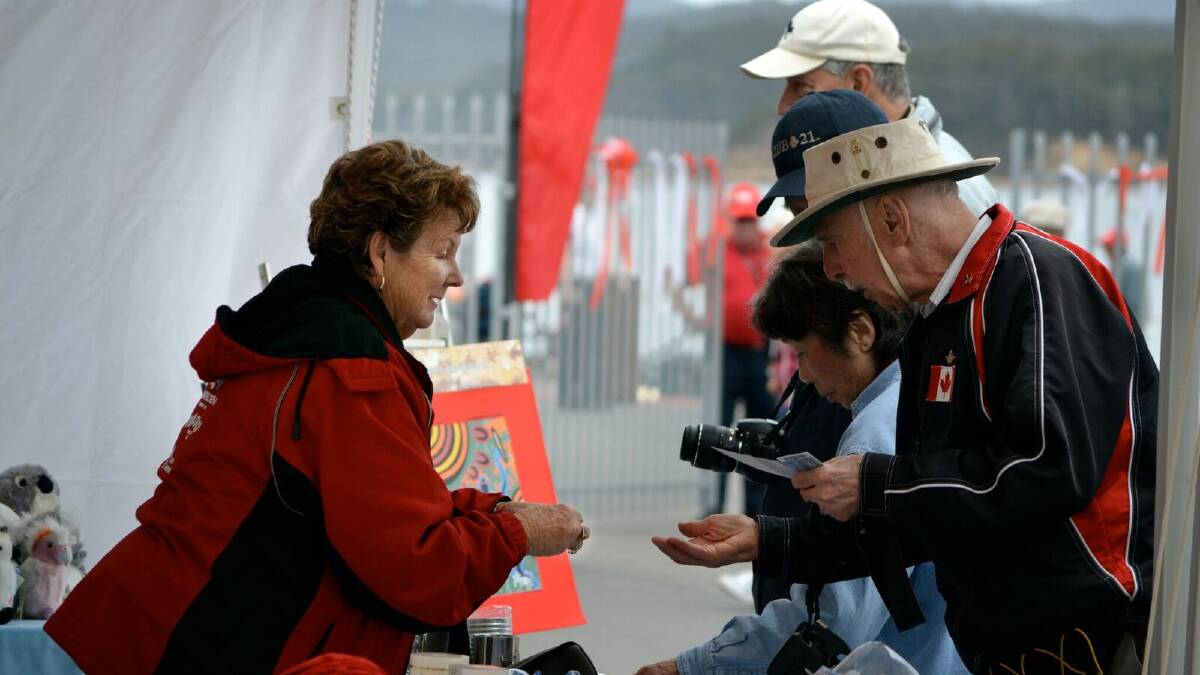 Marge Snijder talks with cruise ship passengers at one of the many market stalls at the wharf