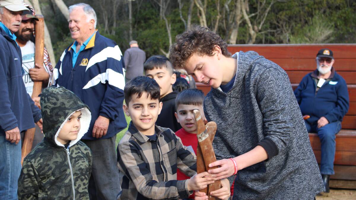 Culture shared: Brytan Aldridge shows boomerangs to some of the children from refugee families who visited the Bega Valley last weekend.