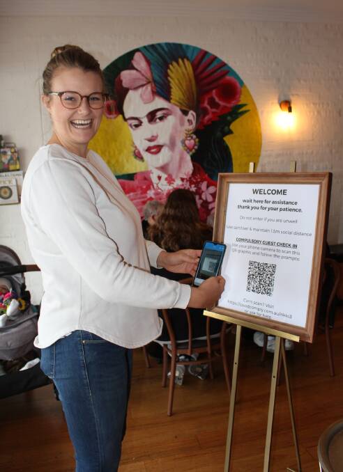 COVID SAFETY: Nicky Austin, one of the owners at Toast, Pambula scans the QR code at the cafe which provides contact tracing information.