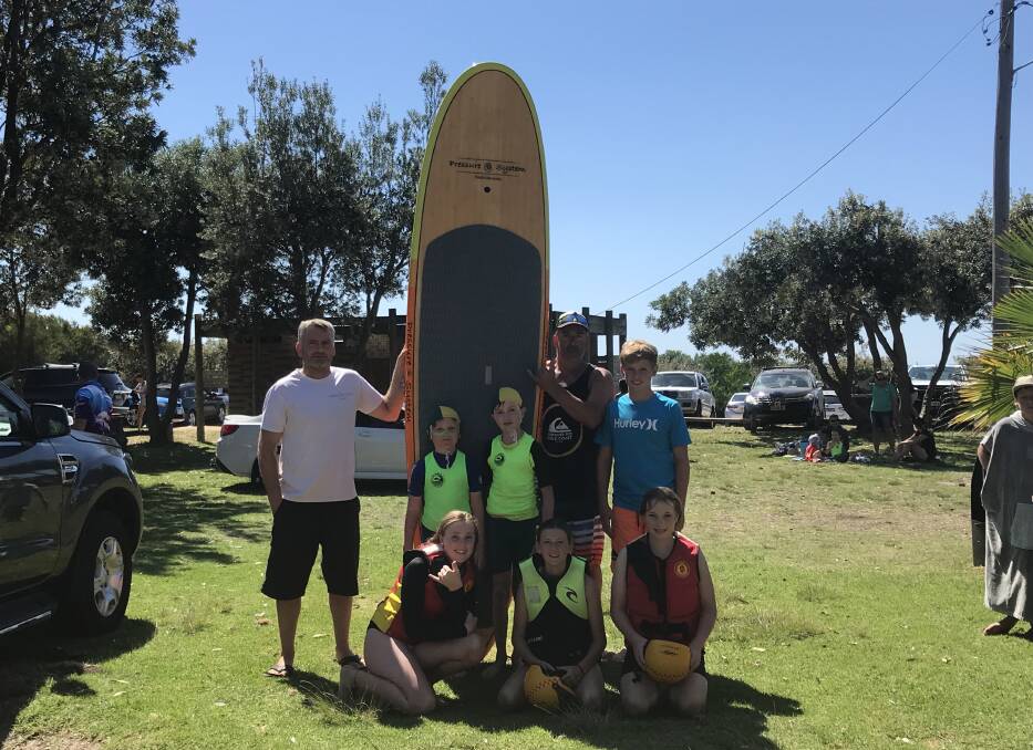 Steve Farley, paddle board supplier and Little Nippers president Andrew Holt with Nippers, Jacob, Liam, Kai, Annabelle, Niamh and Bella.