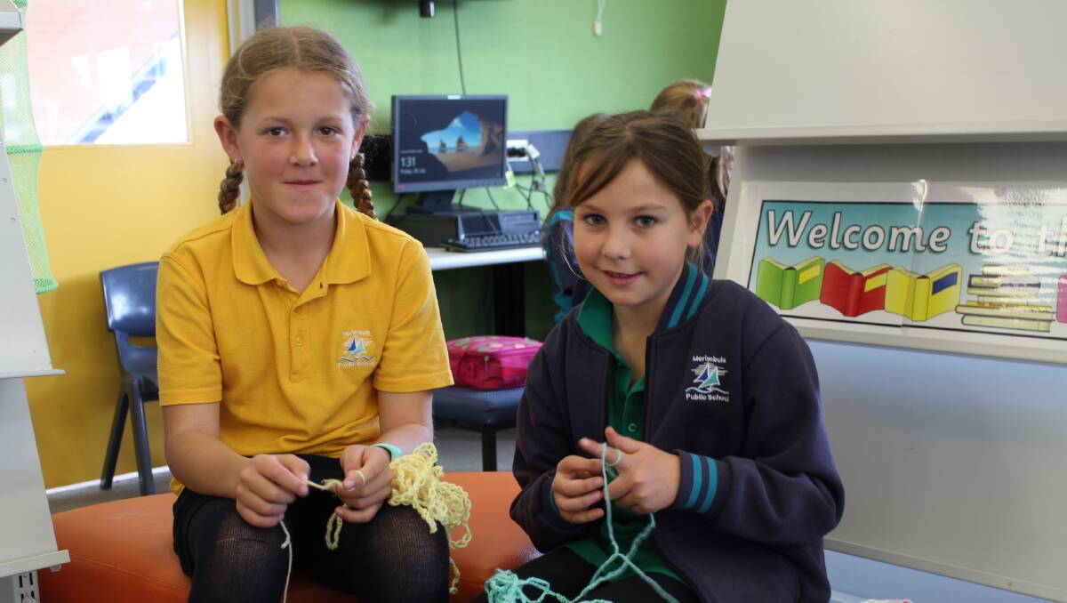 Kyla Burhop and Amelia Ford have got into finger knitting as part of the yarn bombing project and Merimbula Festival that opens at the Old School Museum.