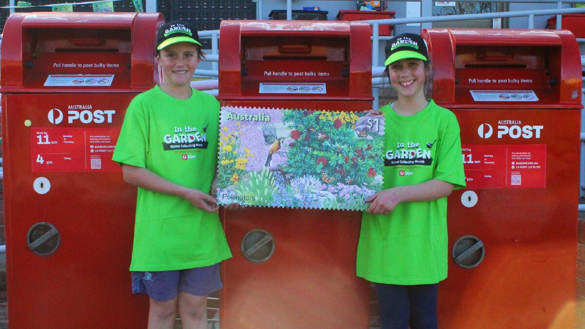 Brother and sister Rafael Chabrier and Perrine Chabrier outside Merimbula Post Office with a large version of one of the new stamps.