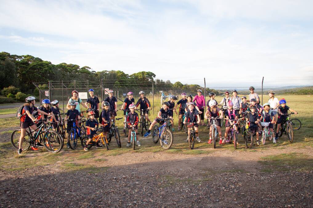 A large group of Lumen Christi Catholic College students get ready to set off from Merimbula on their bikes.