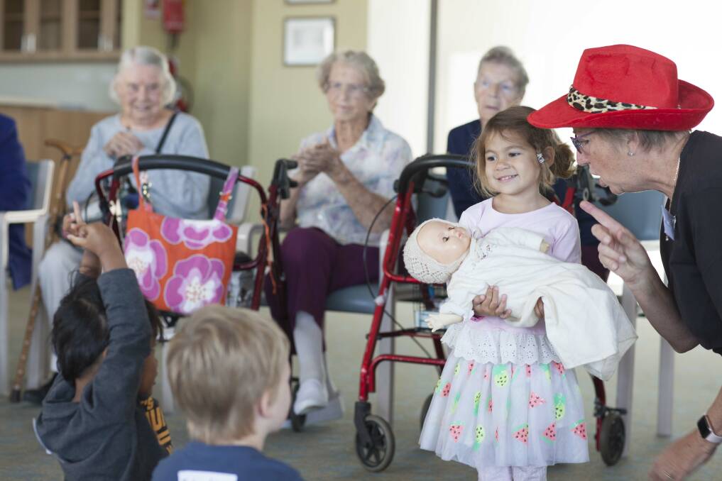 Miss Polly had a dolly: The elderly residents watch on as Hope, 3, delights in being Miss Polly. Photo: Rachel Mounsey