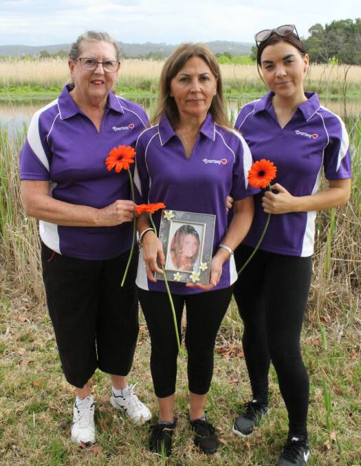 NEVER FORGETTING: In Panboola, Jane Hull holds a photograph of her daughter Courtney, surrounded by her friend Shirley Rixon and her daughter Bonney Hull. 