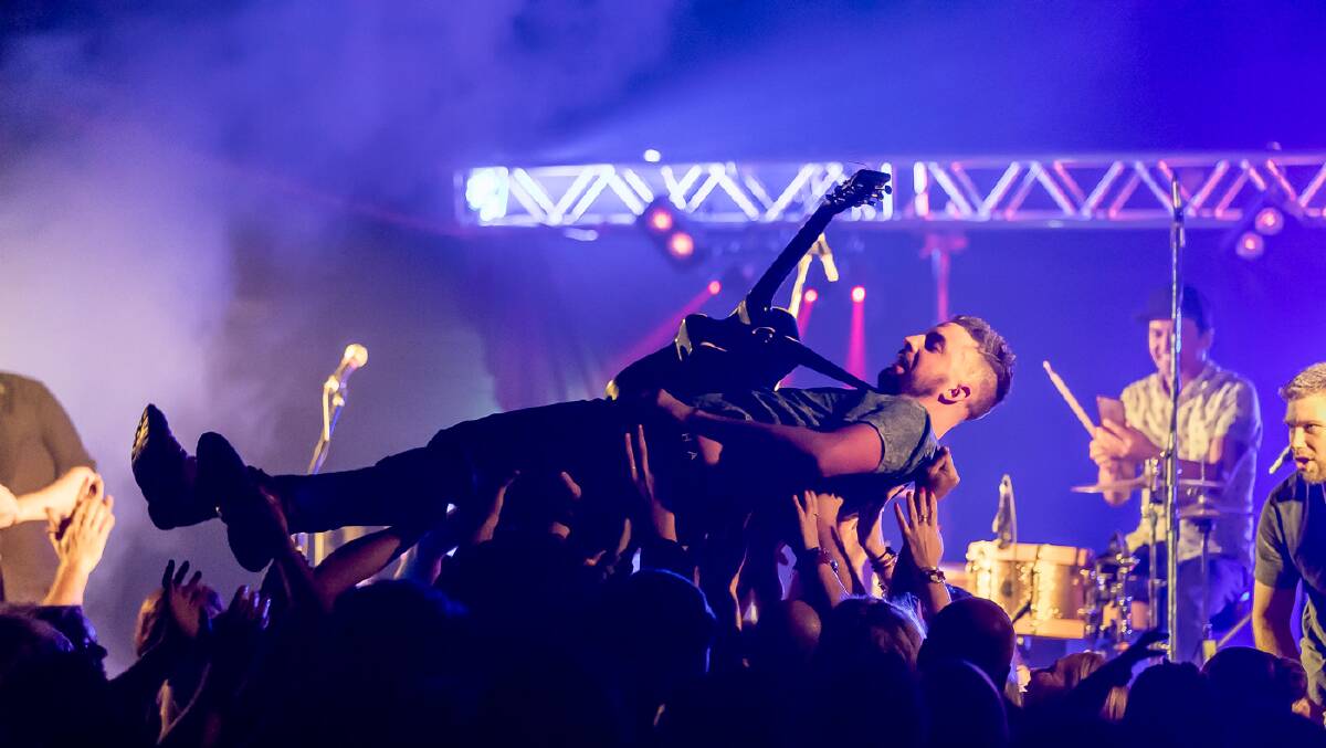 Kane Dennelly surfs the crowd at a concert. Picture: Johnny D Photography 