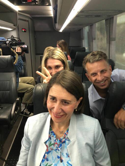 Mary photobombs her sister Premier Gladys Berejiklian with Transport Minister Andrew Constance also joining in the fun on the Liberal campaign bus in March 2019. Photo: Lisa Visentin