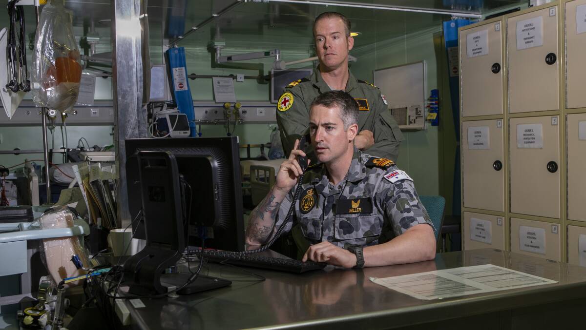 HARD AT WORK: HMAS Adelaide's Lieutenant Commander Thomas Miller (front) and Lieutenant Travis Robinson in the treatment room. Picture: ABIS Thomas Sawtell