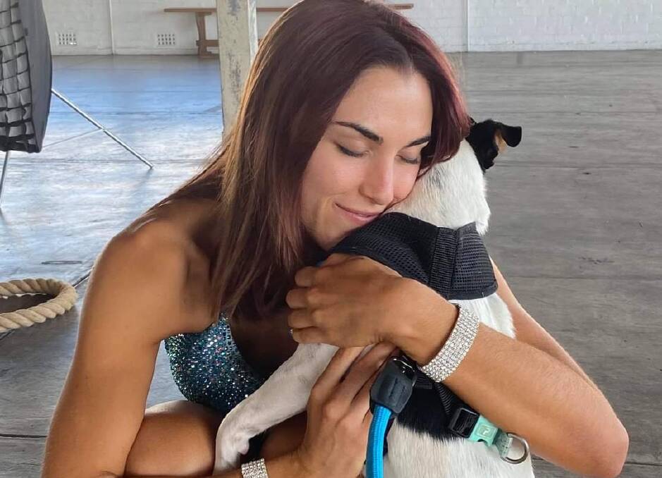 Hannah Hawkes shares a cuddle with her puppy Janis after winning a bodybuilding pro card recently. See sport for more. 