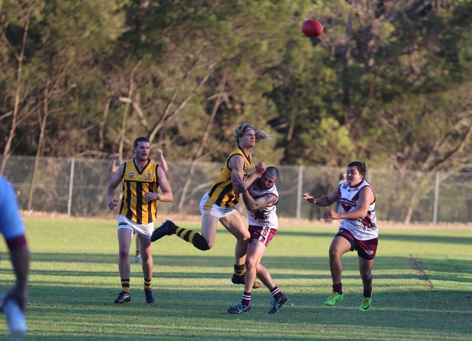 Working: A Pambula Panther gets a handball loose during a tackle attempt by the Tathra Sea Eagles on Saturday, but the Eagles stole the show late in the game. 