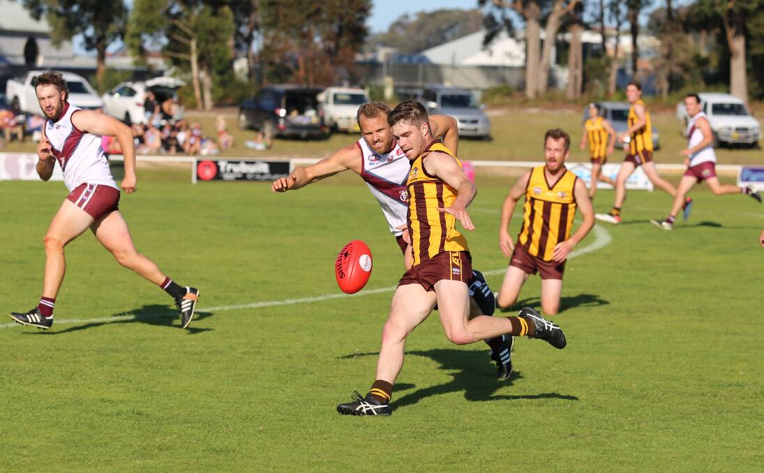 A Pambula Panther gets a kick into the forward lines during a ball contest in the close battle with Tathra on Saturday. 