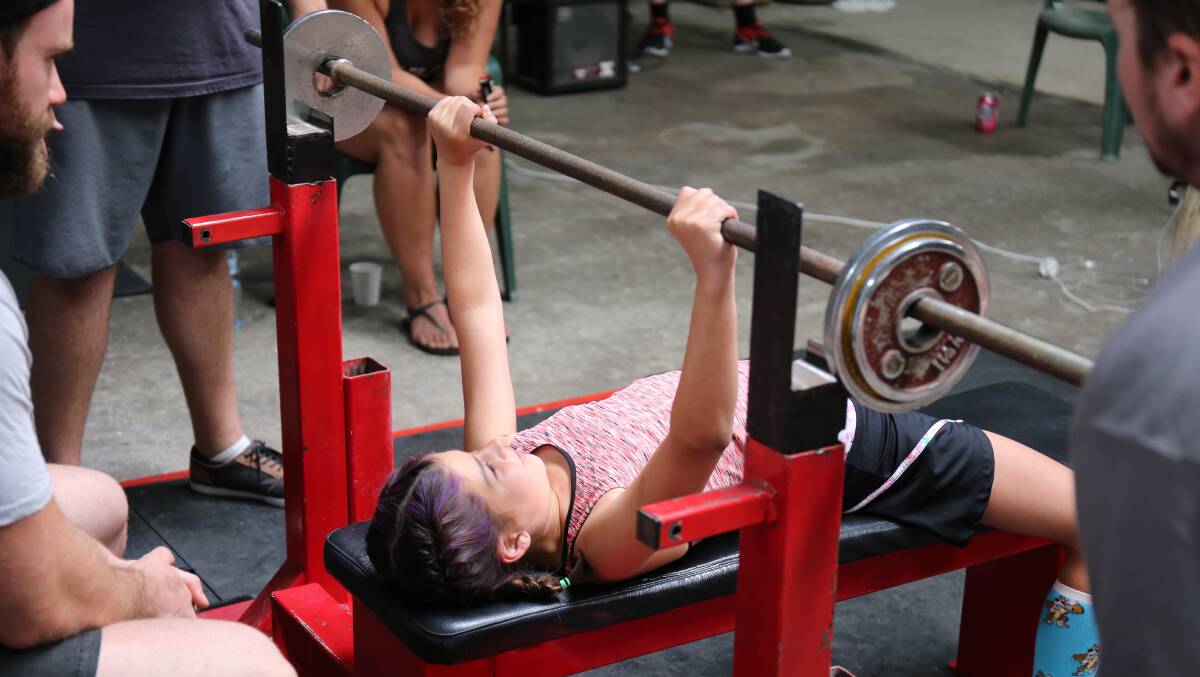 Strong youngster: Bella Tsogas, 10, easily accounts for this 17.5kg bar in the bench press section of competition at the Iron Stronghold on Saturday. 