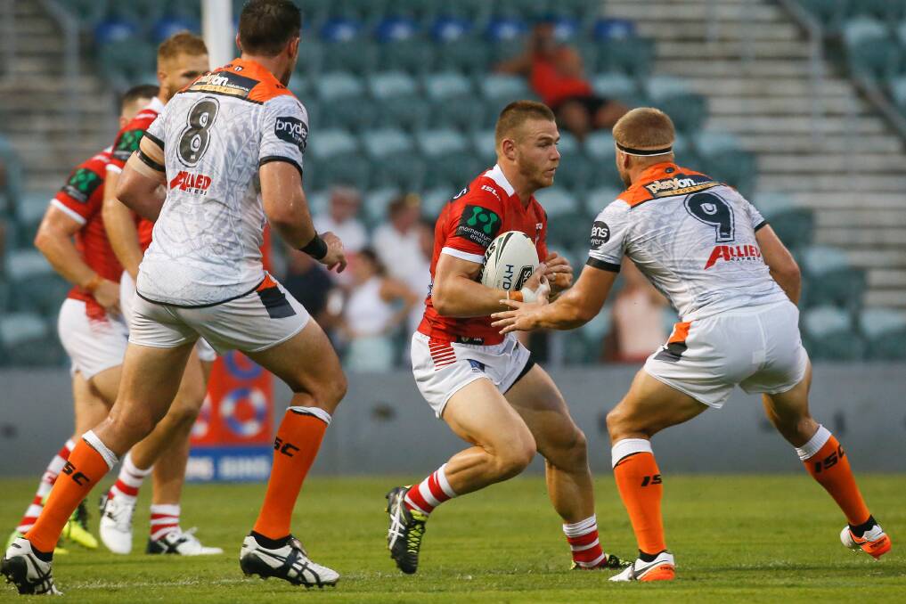 Locked in: Euan Aitken makes a run for the Dragons during a trial game against the Wests Tigers on Saturday with the young gun signing a three-year deal. .Picture: Adam McLean.