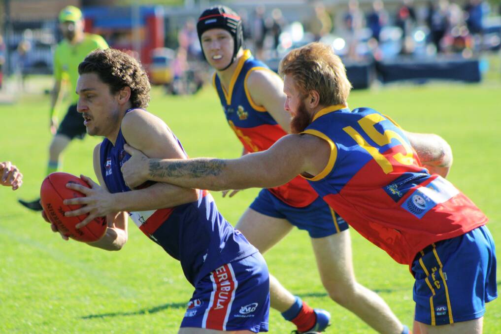 First loss: A Merimbula Digger tries to shake off a tackle attempt by the Narooma Lions at Bill Smyth Memorial Oval on Saturday. 
