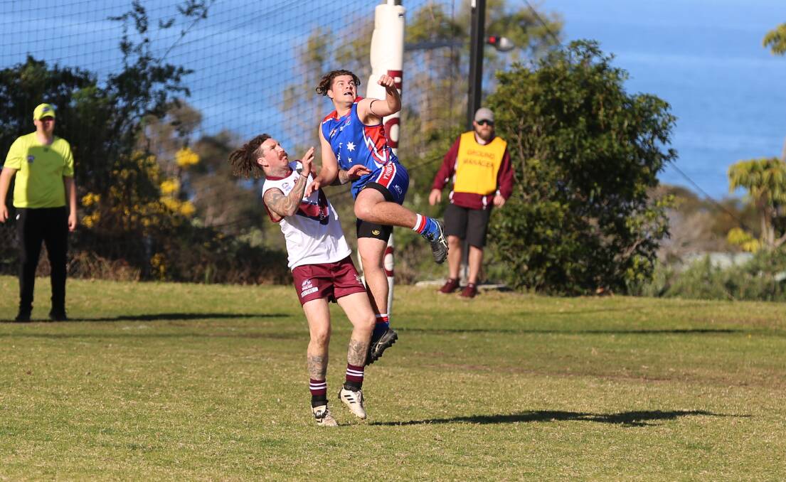 Merimbula Diggers defender Max Geaghan flies up in a mark contest with Tathra forward Clinton Phillips at Lawrence Park on Saturday. 