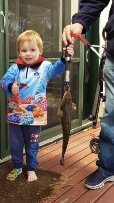 Young gun: Three-year-old Lachlan Wilkins, with a little help from Dad, Jarryd, shows his first ever Dusky Flathead taken at Wonboyn.  