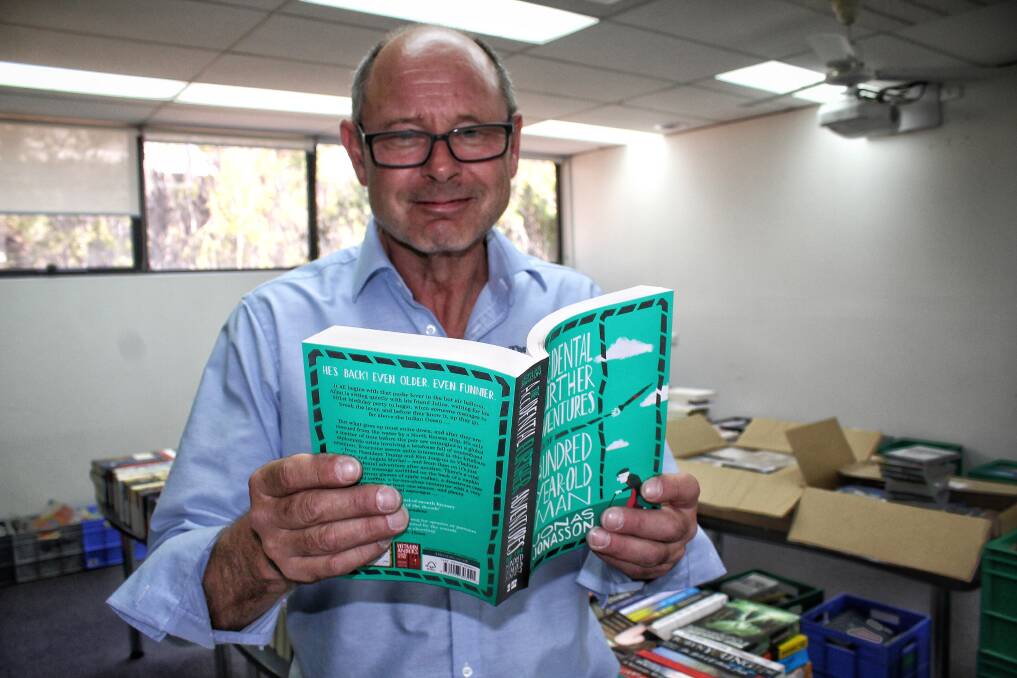 NEW SELECTIONS: The Book House's Roland Yetman in the Bega library on Tuesday with one of his favourite reads of 2018. Picture: Alasdair McDonald 