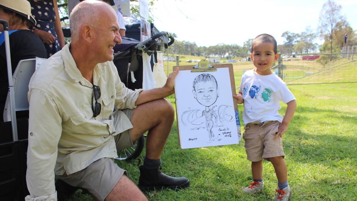 FUN DAY OUT: Marco Osta from Melbourne gets his portrait done while visiting grandpa Shane Osta of Merimbula. Photo: Alana Beitz