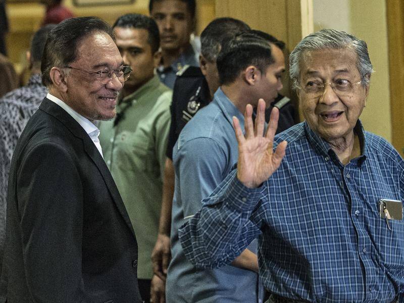 Malaysian PM Mahathir Mohamad (R), shown with Anwar Ibrahim, has told the king he's resigning.